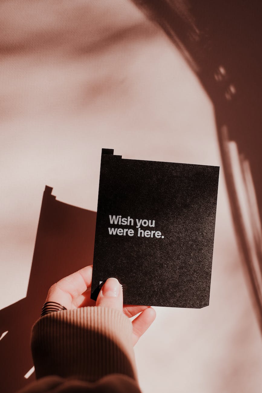 person holding black card with white texts