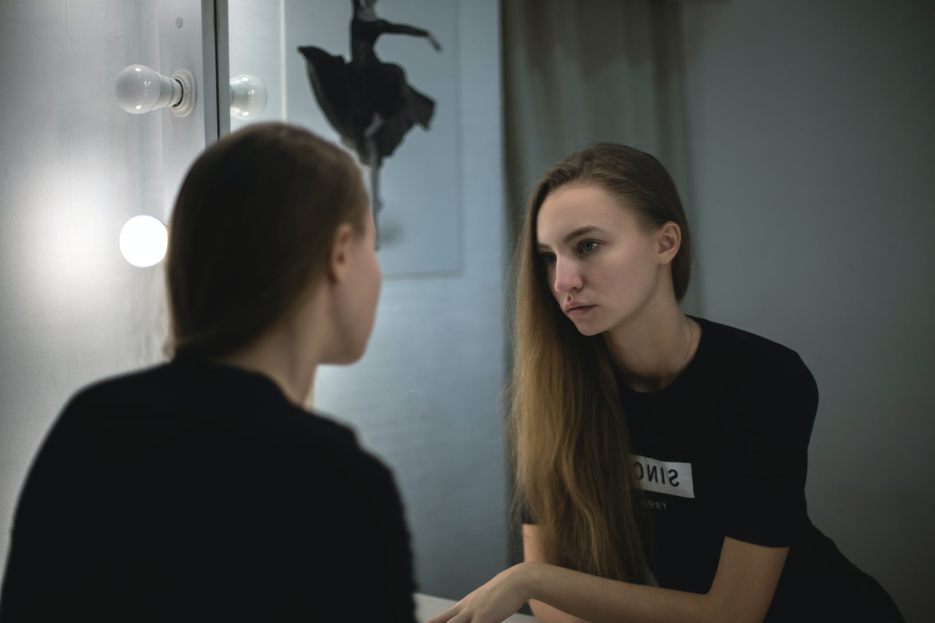 woman in black shirt facing mirror