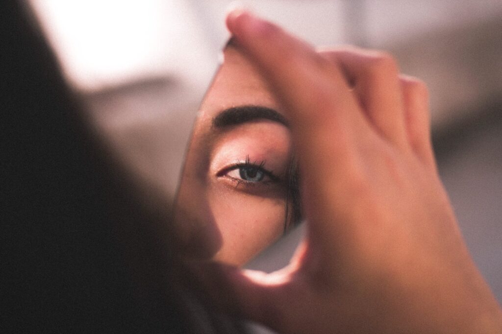 reflection of woman s eye on broken mirror