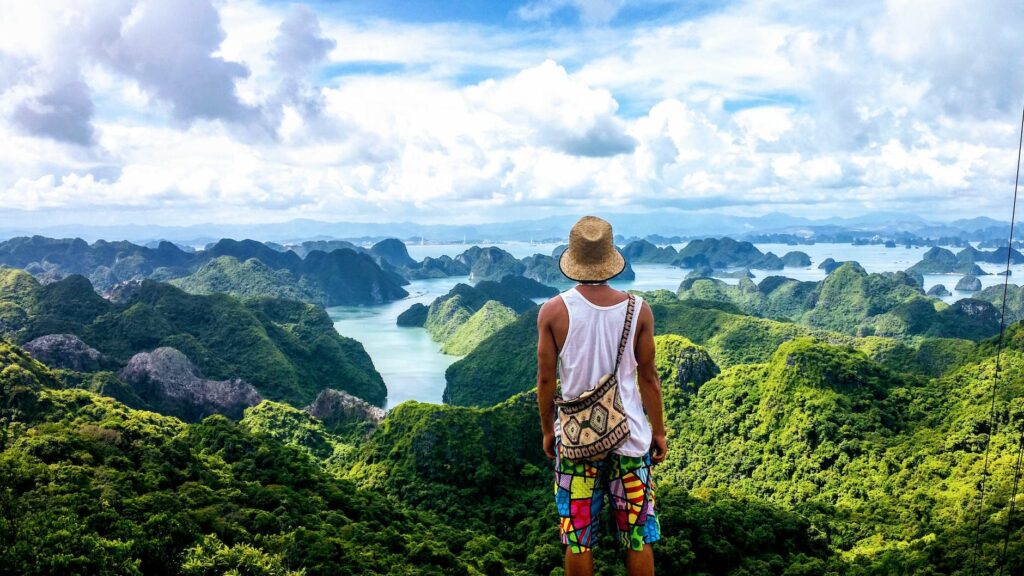 man standing and facing mountains